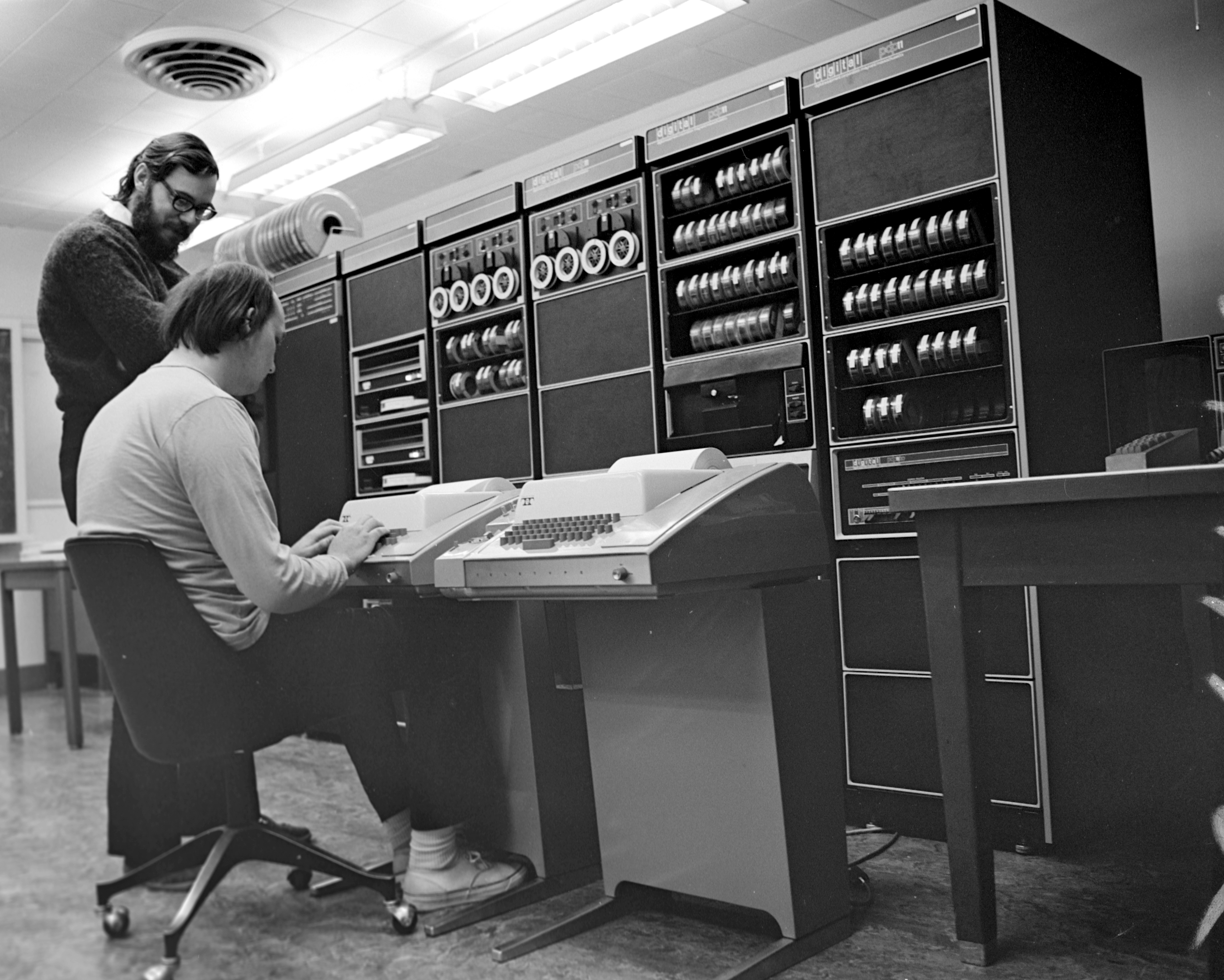 Ken Thompson and Dennis Ritchie sitting at a PDP-11 Mainframe